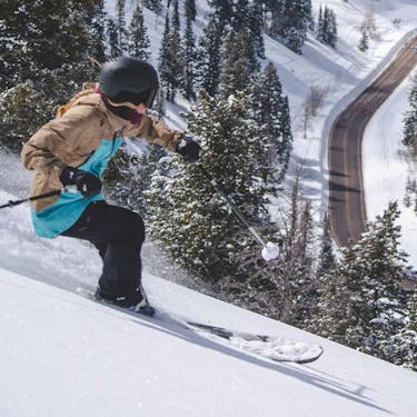 A skier rides through powder above Highway 158
