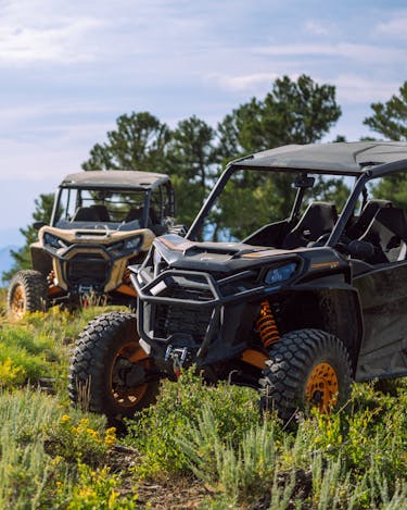 Two UTV's parked on a hilltop with sagebrush