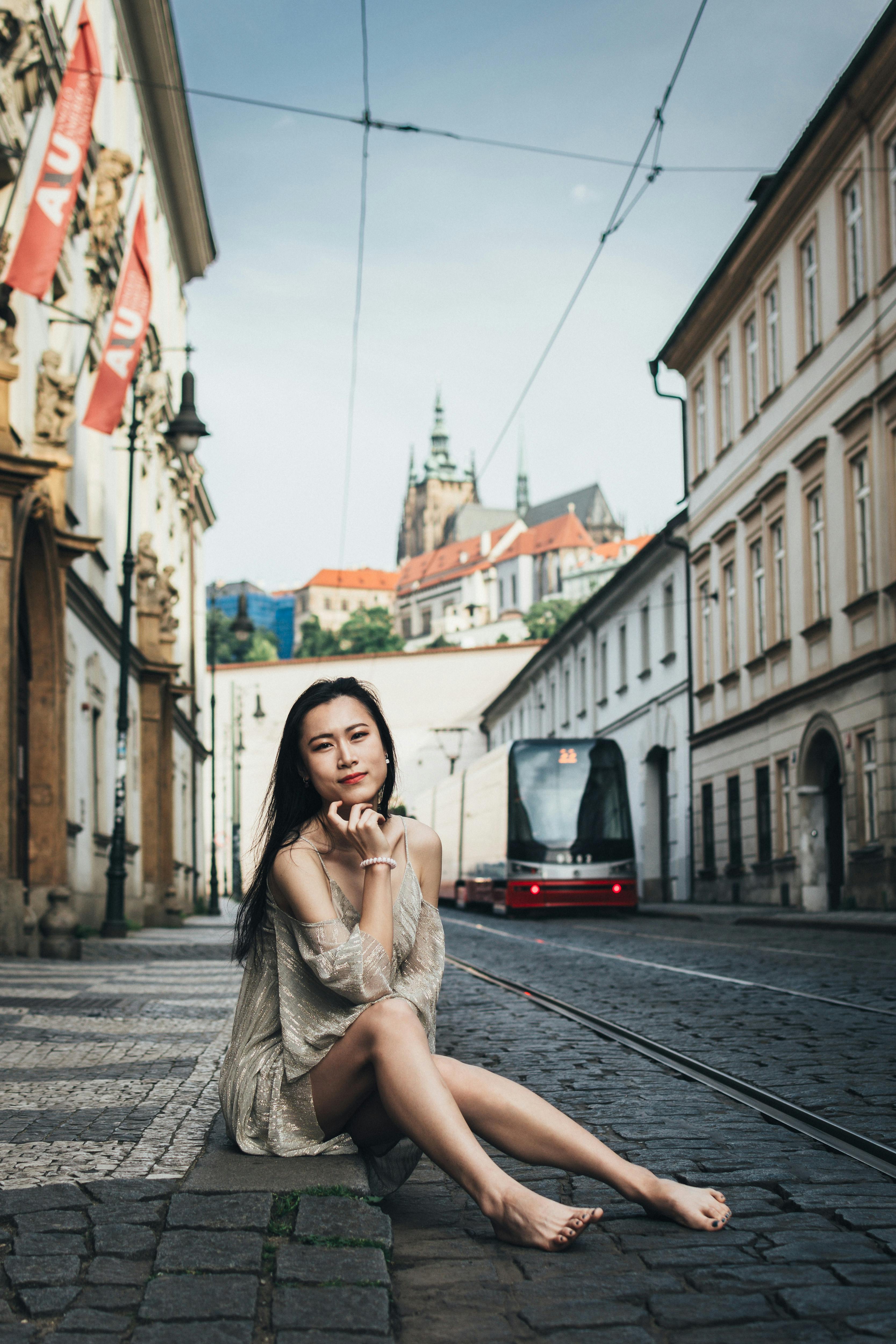 An Asian girl posing for a videoshoot in front of the Prague Castle photographed by Prague Photographers.