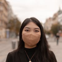 An Asian girl wearing the Respilon brand mask photographed the Wenceslas Square by Prague Photographers.