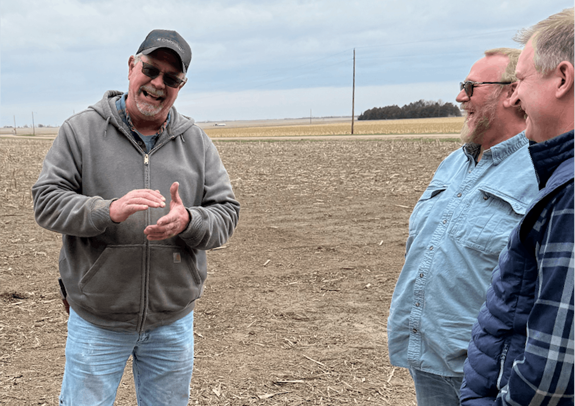 3 men standing on the ground and smiling