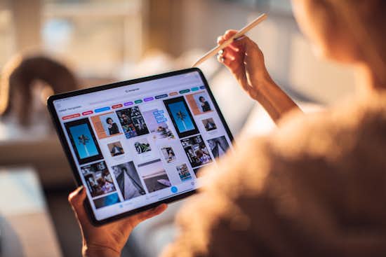Decorative image of person holding a tablet showing inspirational and fashion images Decorative image of person holding a tablet showing inspirational and fashion images