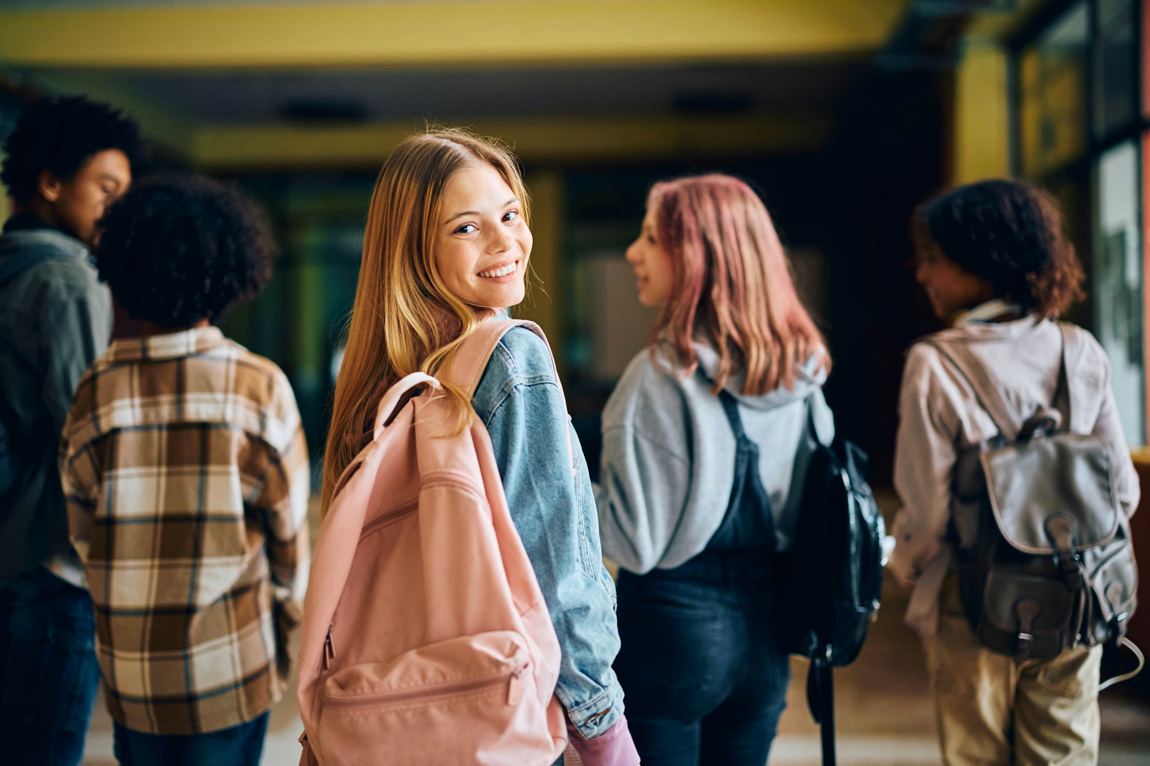 High School students walking in a college campus hallway together