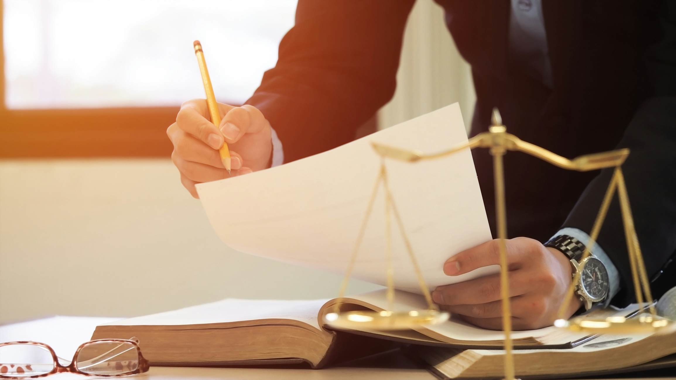 Lawyer writing notes on top of an open book