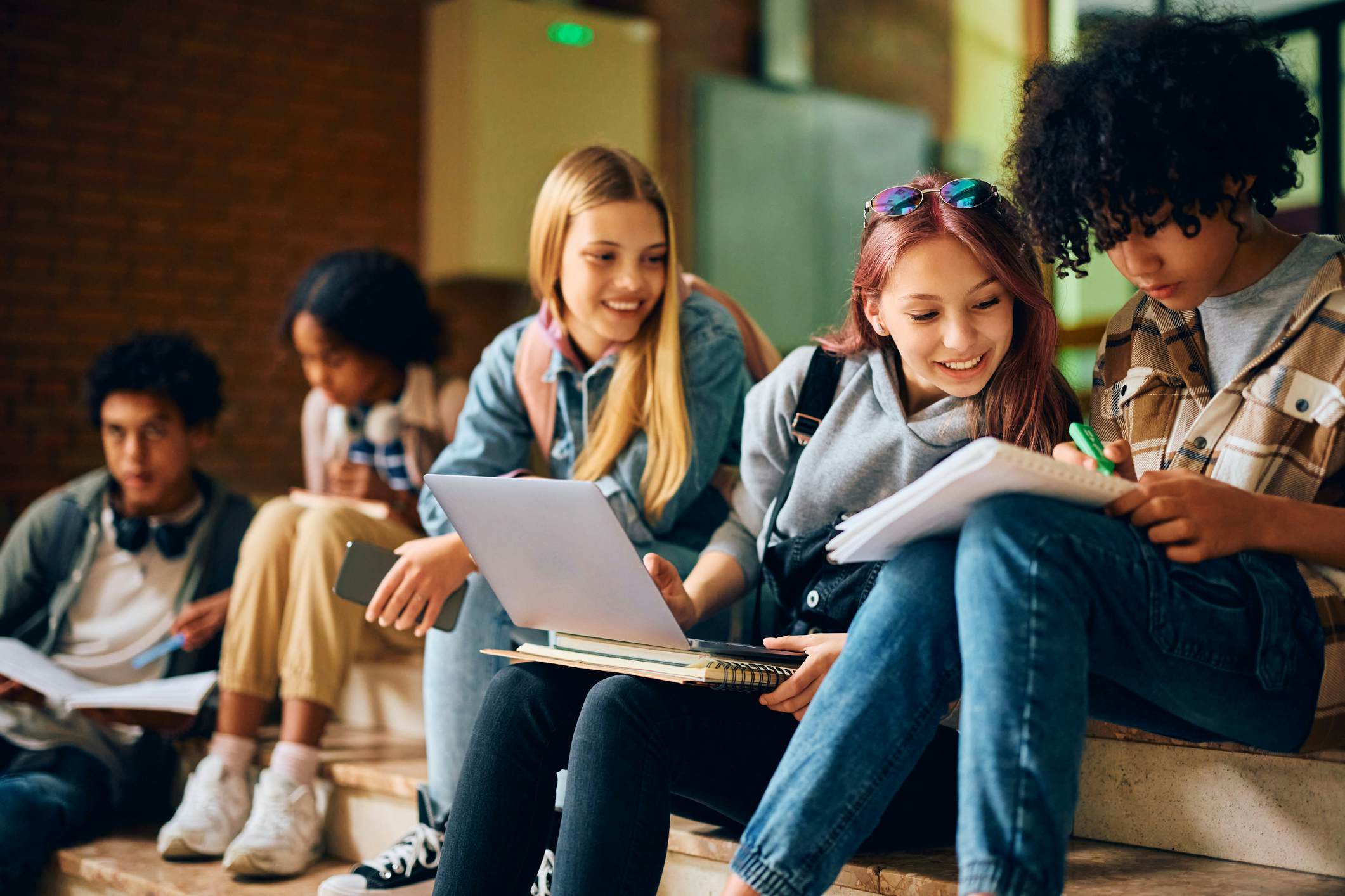 High School students studying on the steps of a University