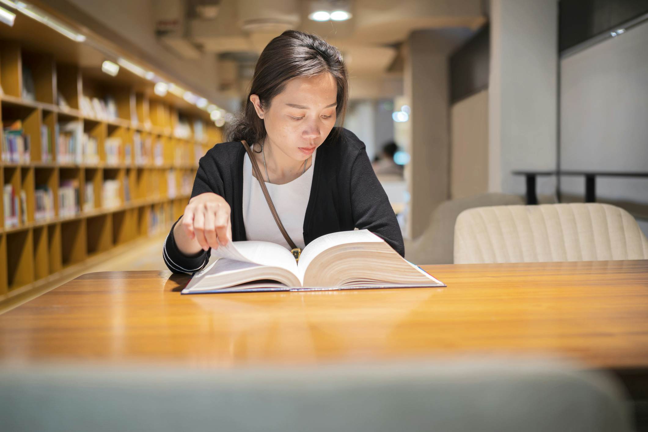 Student reading a law textbook in a library