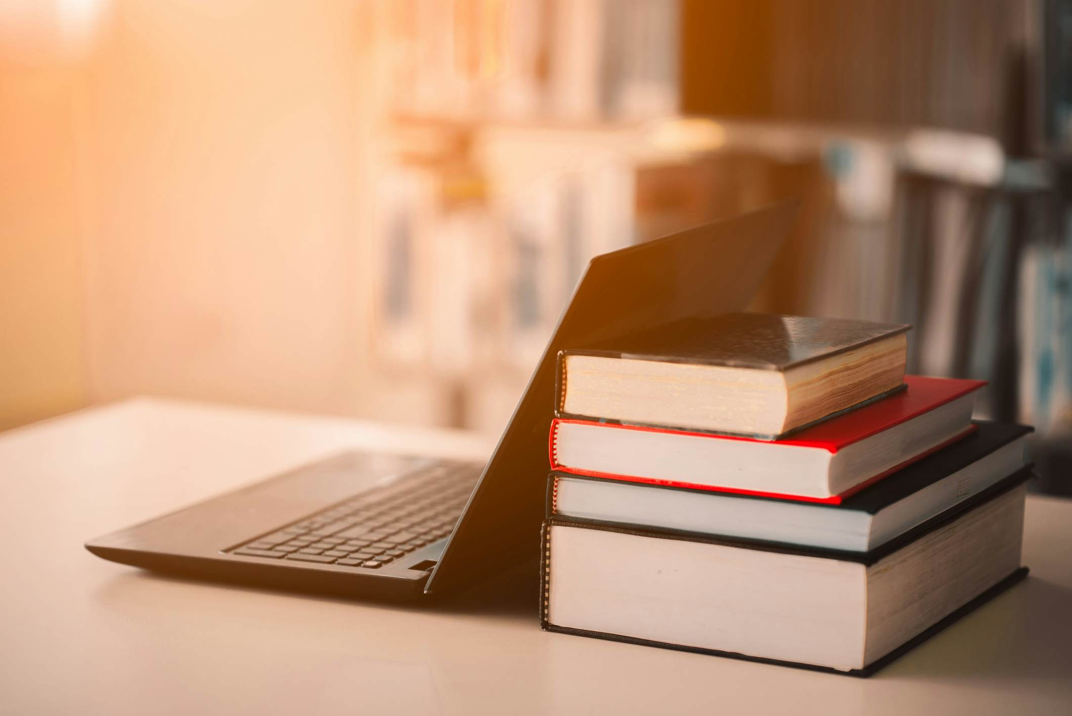 Laptop leaning against a stack of law textbooks