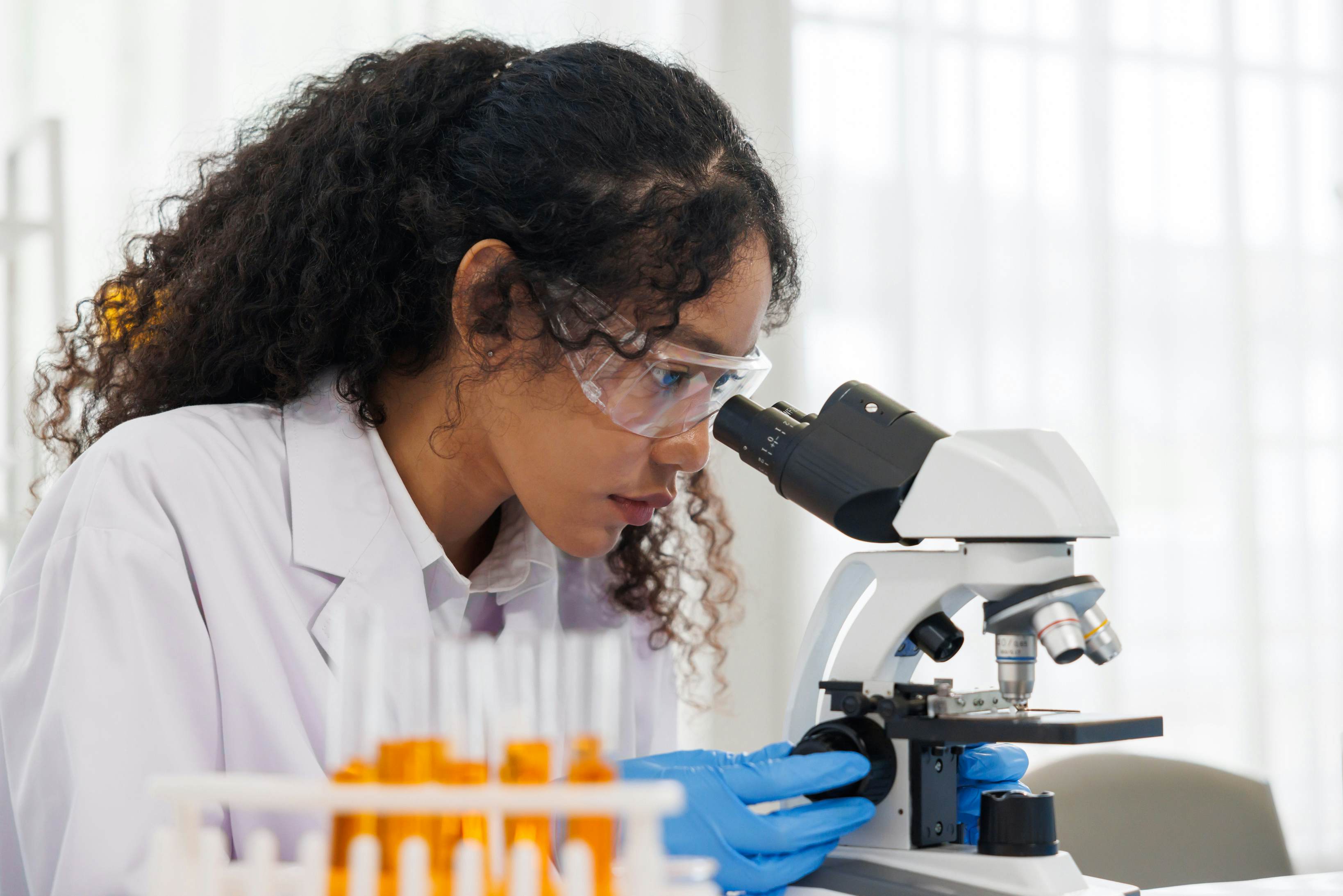 Student examining a sample with a microscope