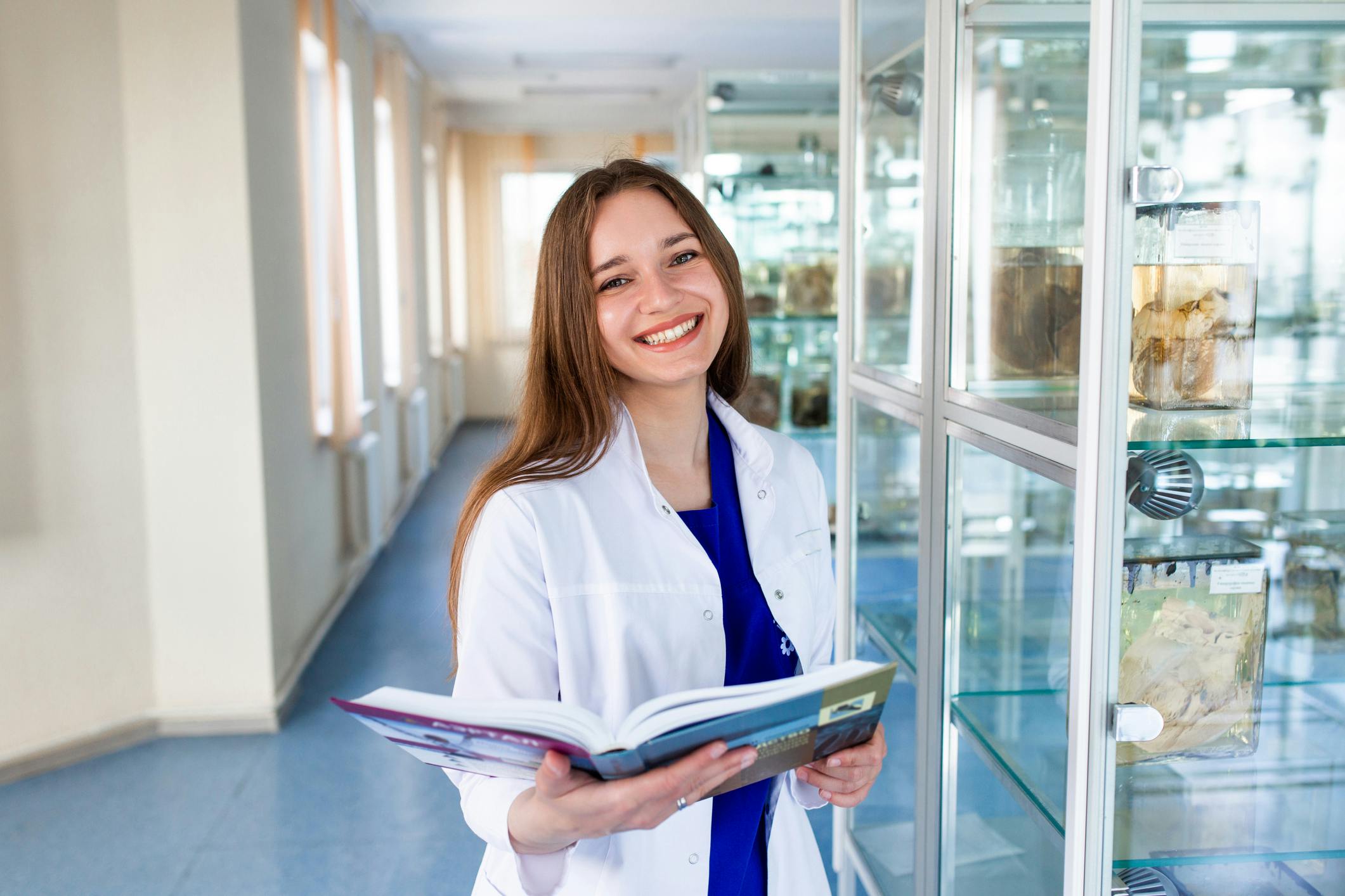 Female medical student standing in front of an cabinet with anatomical items