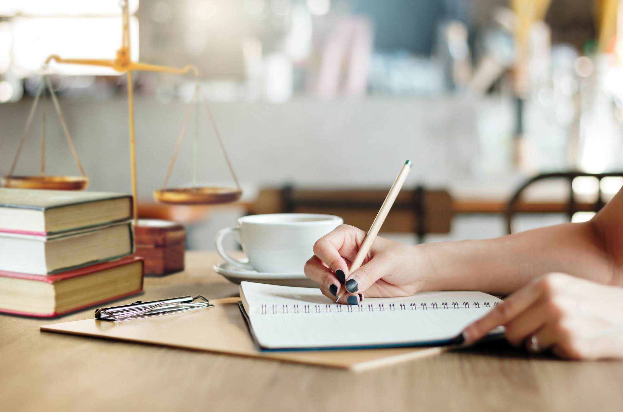 Student writing notes on the law in a notebook