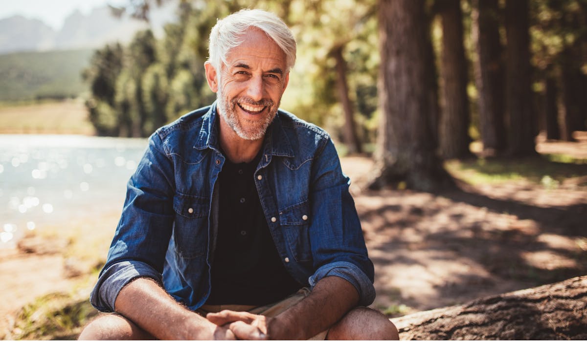 Mature man sitting at the lake.