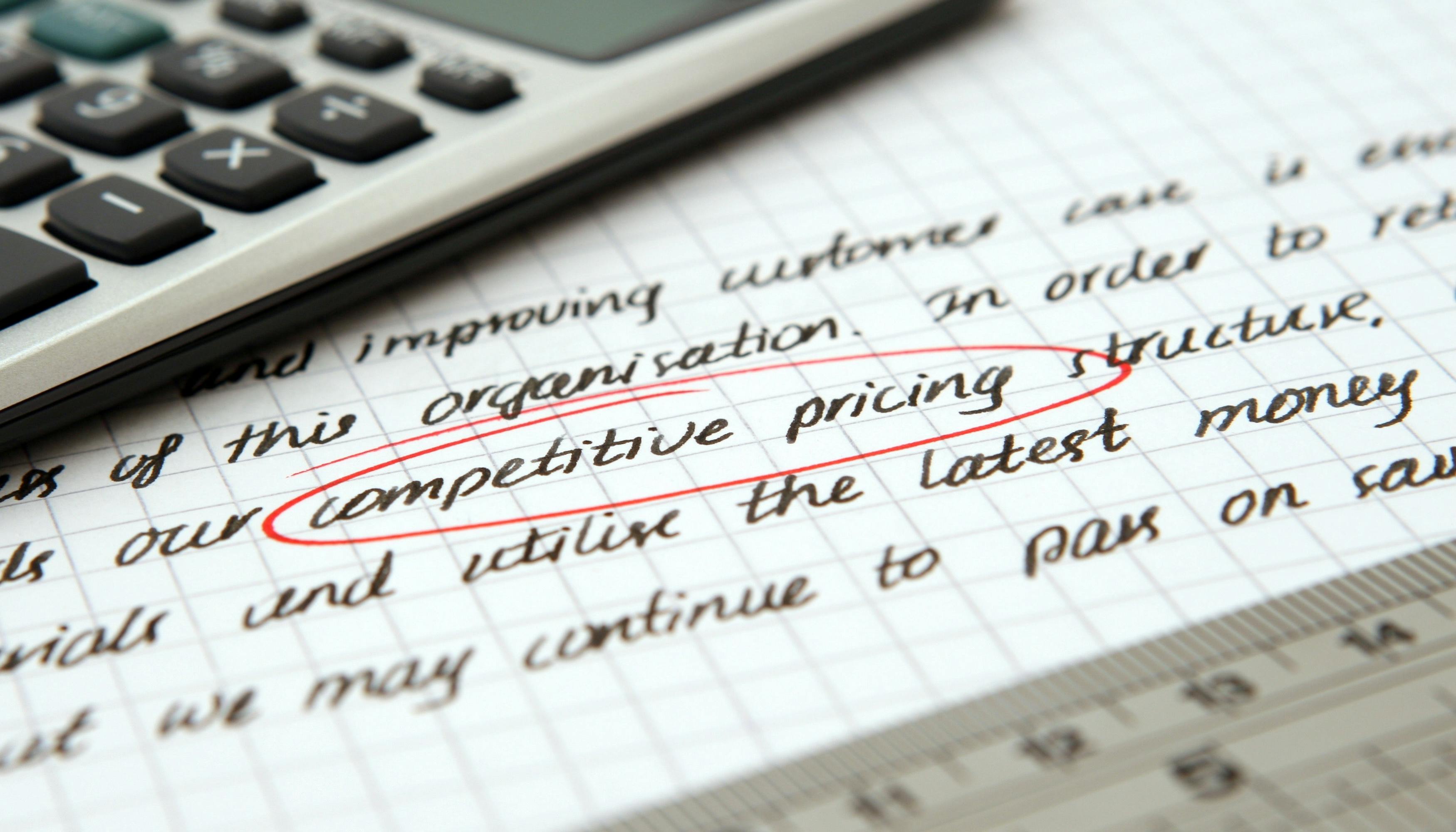 Handwritten note with competitive pricing circled with a calculator and ruler.
