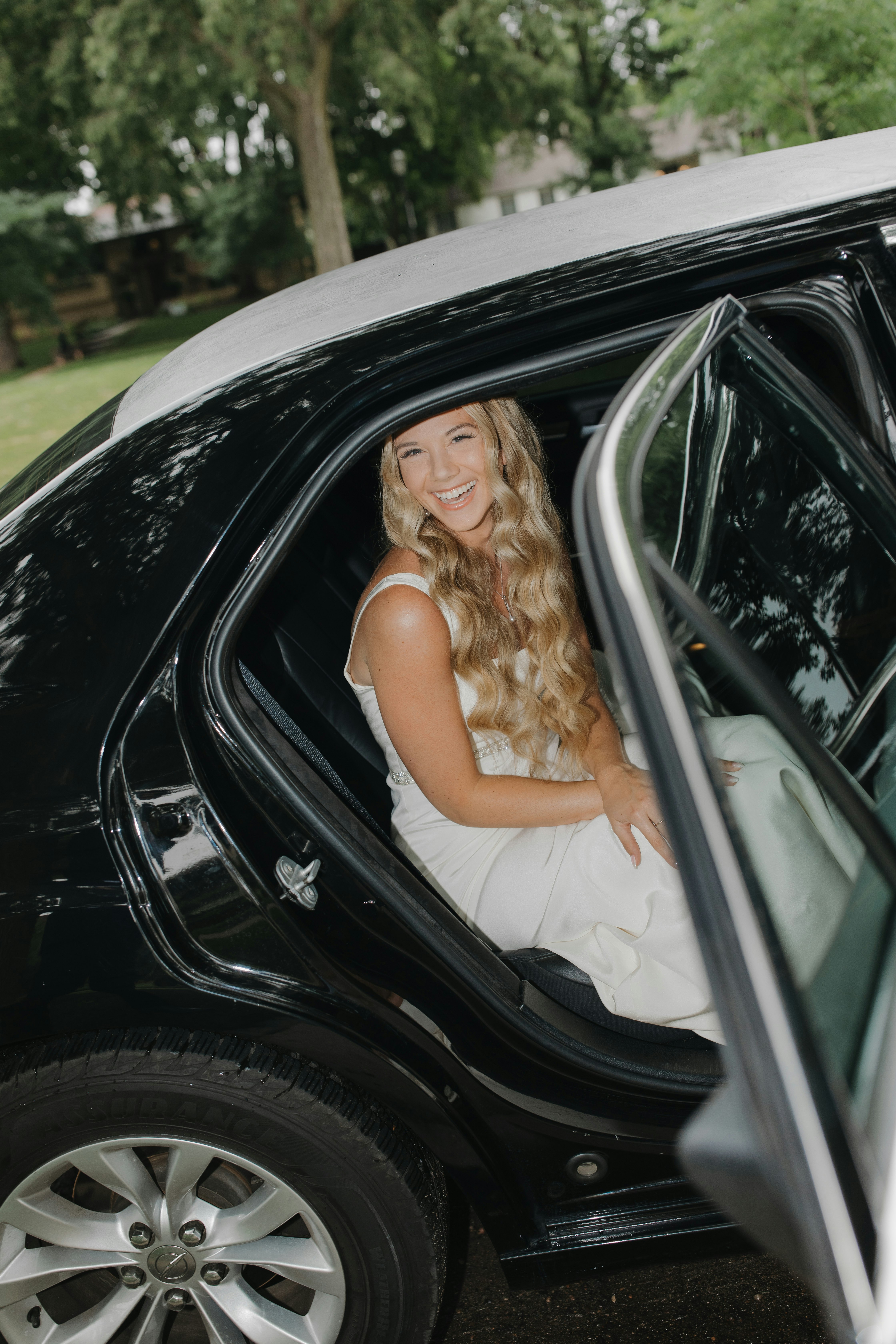 Bride smiling in fancy car