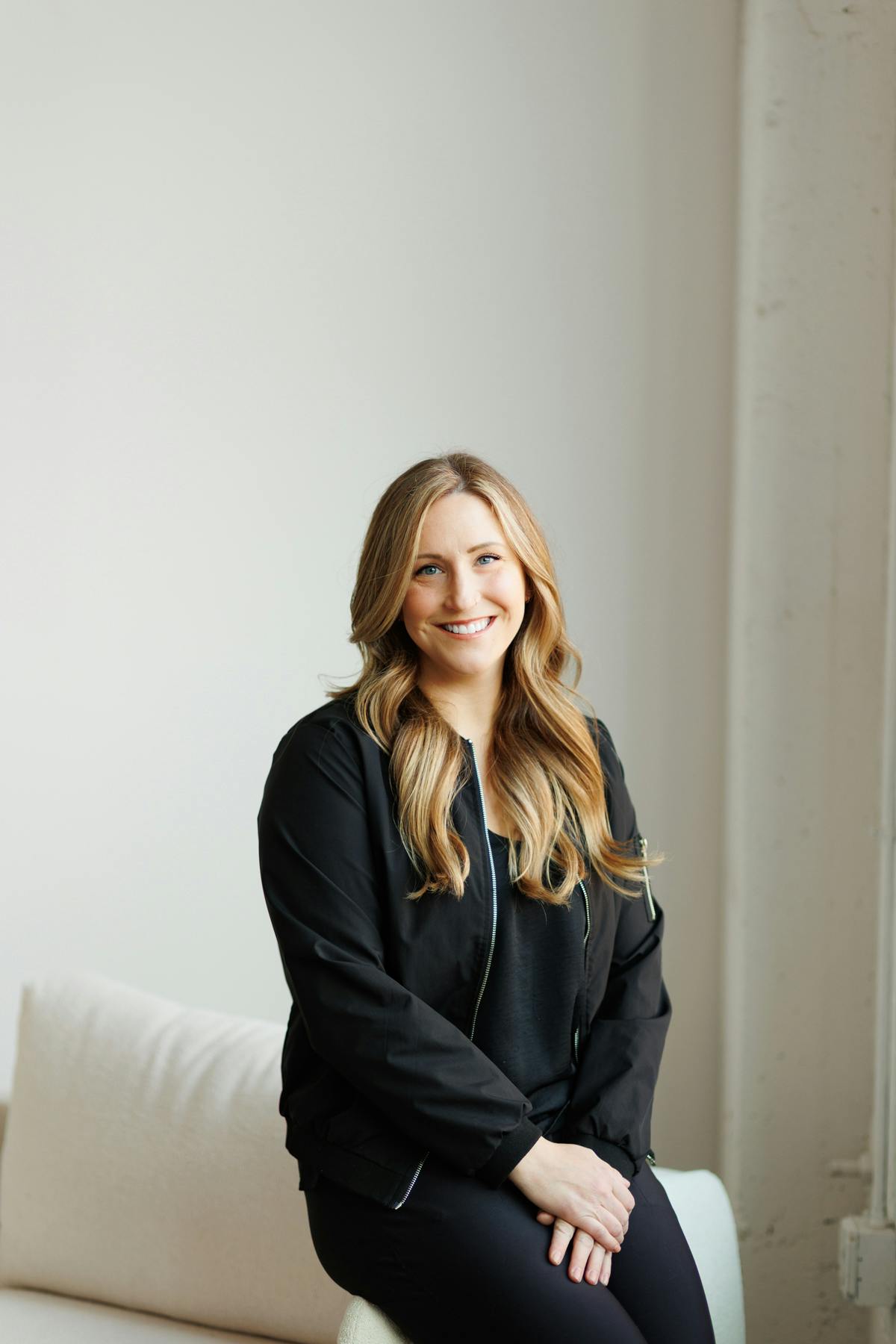 Blond woman in black outfit smiling