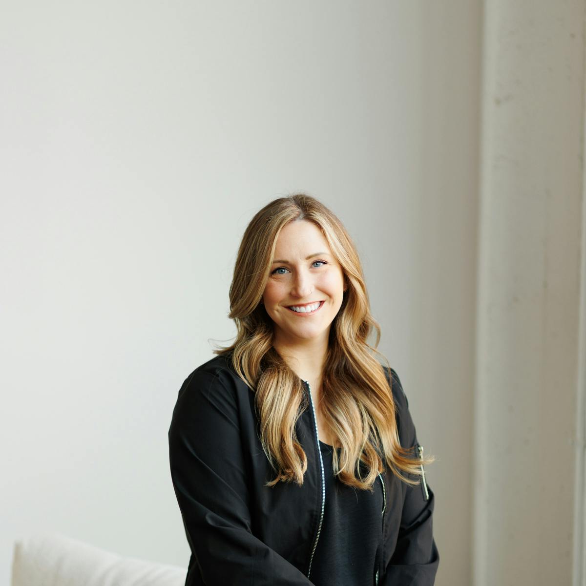 Blond woman in black outfit smiling