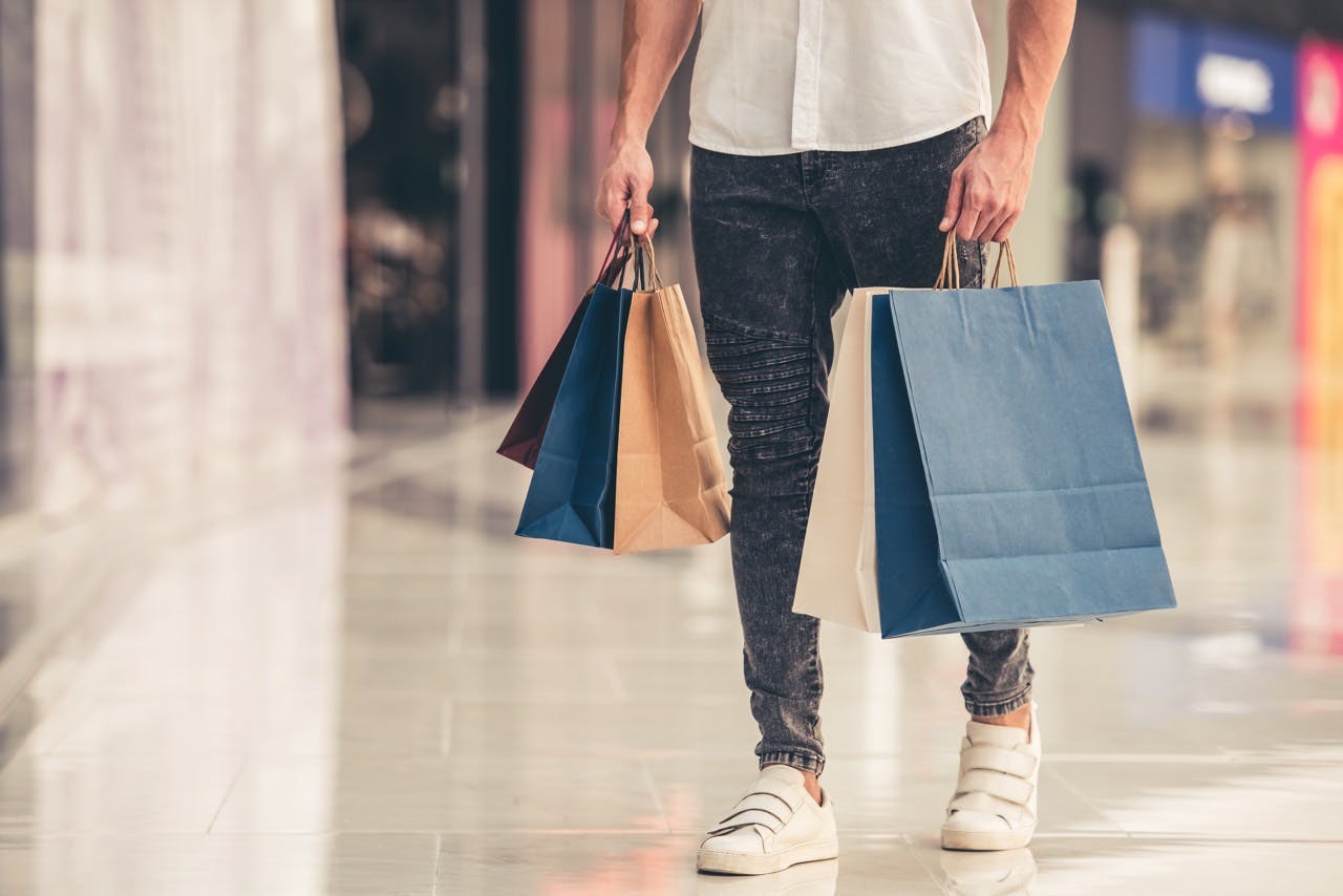 Male holding shopping bags in a mall