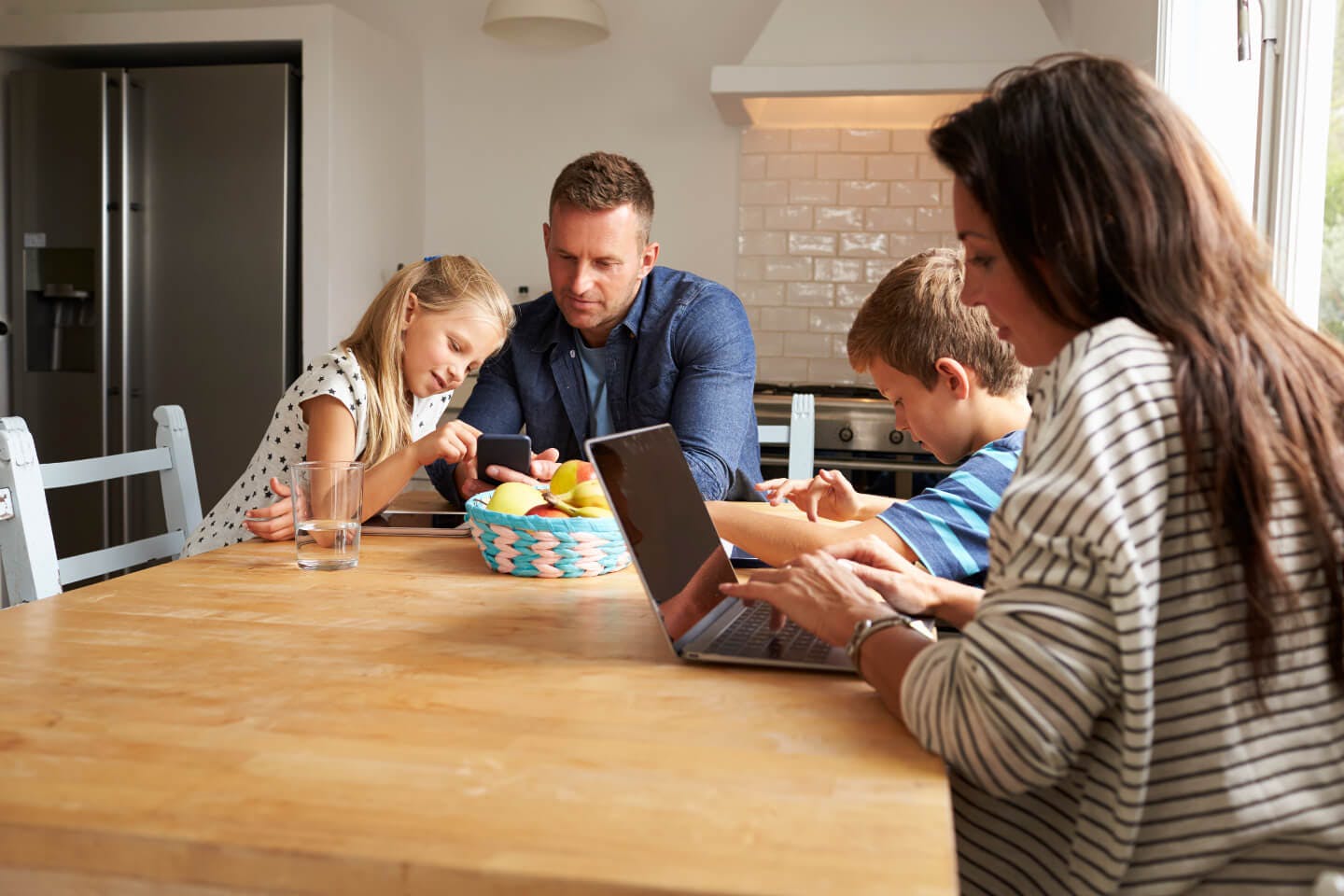Family at table using gadgets