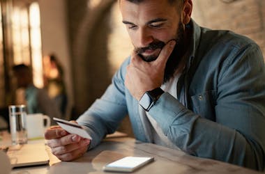 homme qui tient une carte de paiement