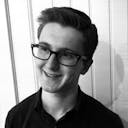 A black and white portrait of Ben smiling.