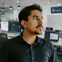 Professional headshot of TJ Kohli, Co-founder, in modern tech office environment