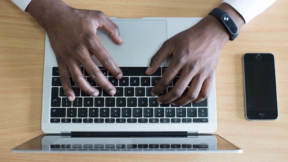 homme qui tape sur son clavier d'ordinateur