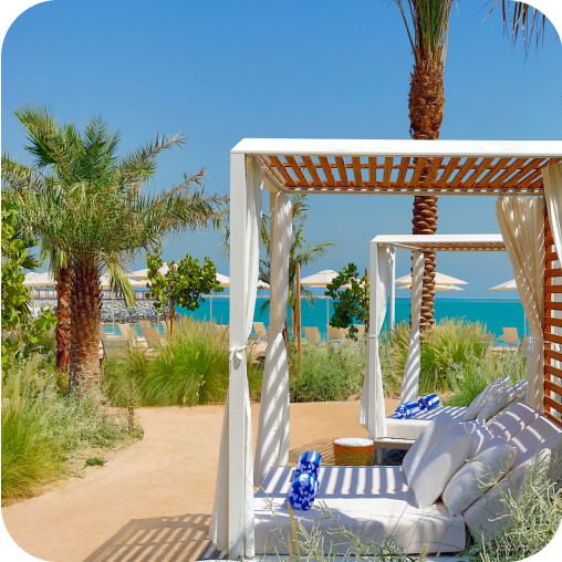 Cabana on the beach, surrounded by palm trees, overlooking the ocean