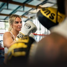 Female boxing with boxing gloves on and working out in a Dubai gym