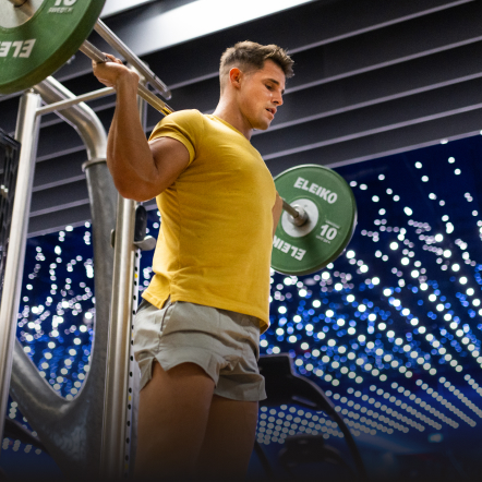 Man doing a back squat during a weightlifting class