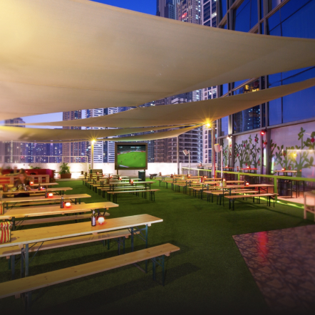 Casual outdoor restaurant nestled amidst lush green grass, with tables and chairs for al fresco dining.