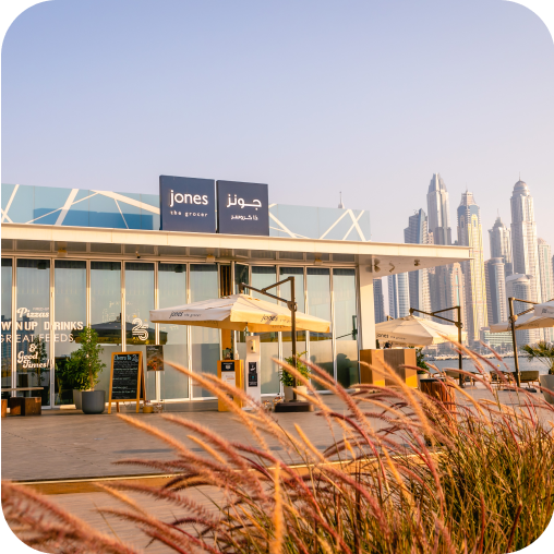 Jones The Grocer on the beachfront of Palm West Beach, Dubai UAE, with skyscraper buildings in the background