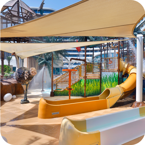 Kids' water play area featuring splash pads and two slides at Waldorf Astoria Lusail, Doha.