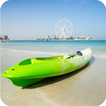 Canoe, water sports and activities on JBR beach, Dubai UAE, with views of Ain Dubai. 