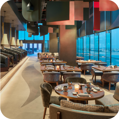 Indoor restaurant view of Akira Back at W Dubai - The Palm UAE, featuring neatly arranged tables and chairs.