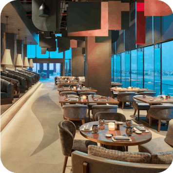 Indoor restaurant view of Akira Back at W Dubai - The Palm UAE, featuring neatly arranged tables and chairs.