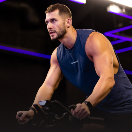 Man women working out in a Dubai gym on a spinning bike