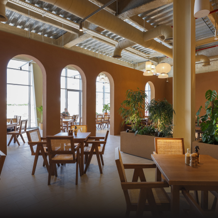 Cosy indoor restaurant adorned with neatly arranged chairs and tables, creating an inviting and comfortable dining atmosphere.