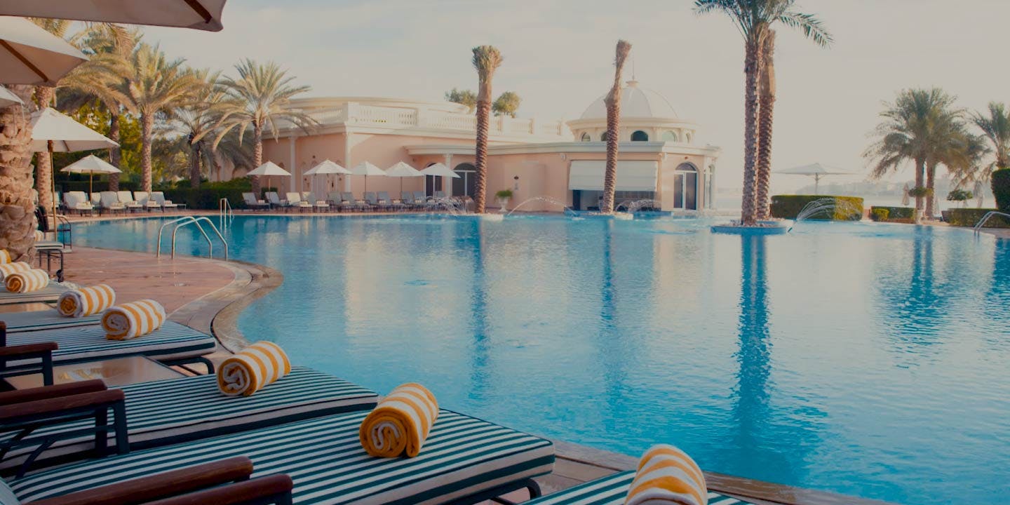 yellow and green stripped sun beds and towels by the pool at Kempinski Hotel & Residences Palm Jumeirah 