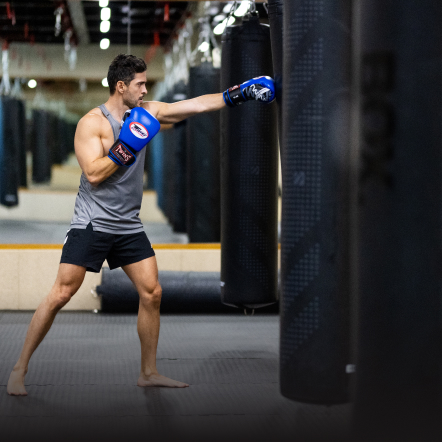 Man boxing with boxing gloves on and working out in a Dubai gym