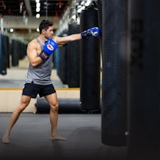 Man boxing with boxing gloves on and working out in Qatar gym
