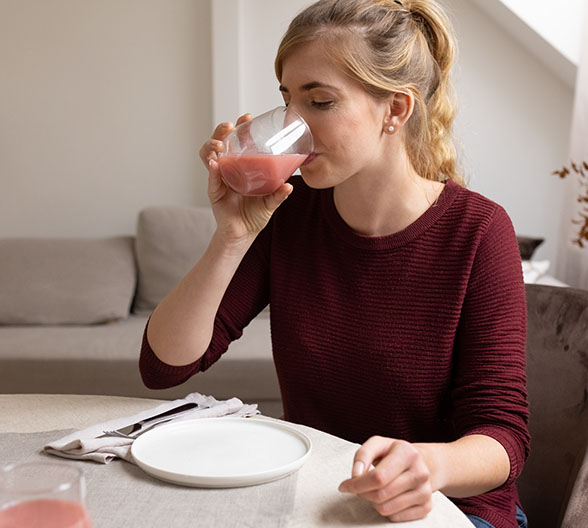 Eine junge Frau, die gerade trinkt. 