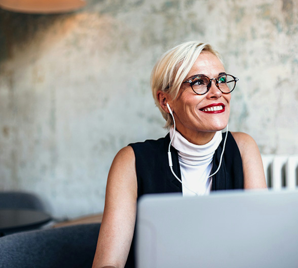 Eine lächelnde Dame, die am Laptop arbeitet