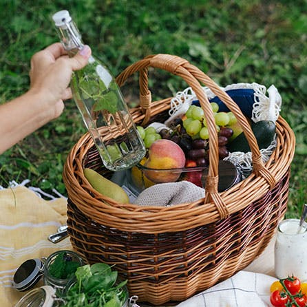 Ein Korb mit Obst und Produkten auf einer Picknick-Decke