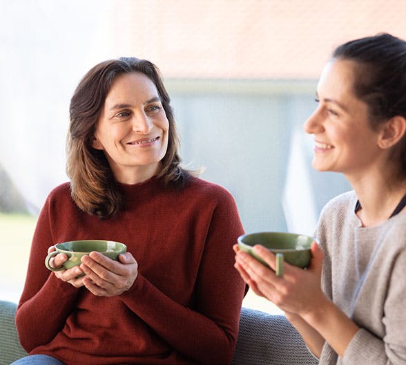 Zwei Frauen, die sich bei einer Tasse Tee unterhalten.