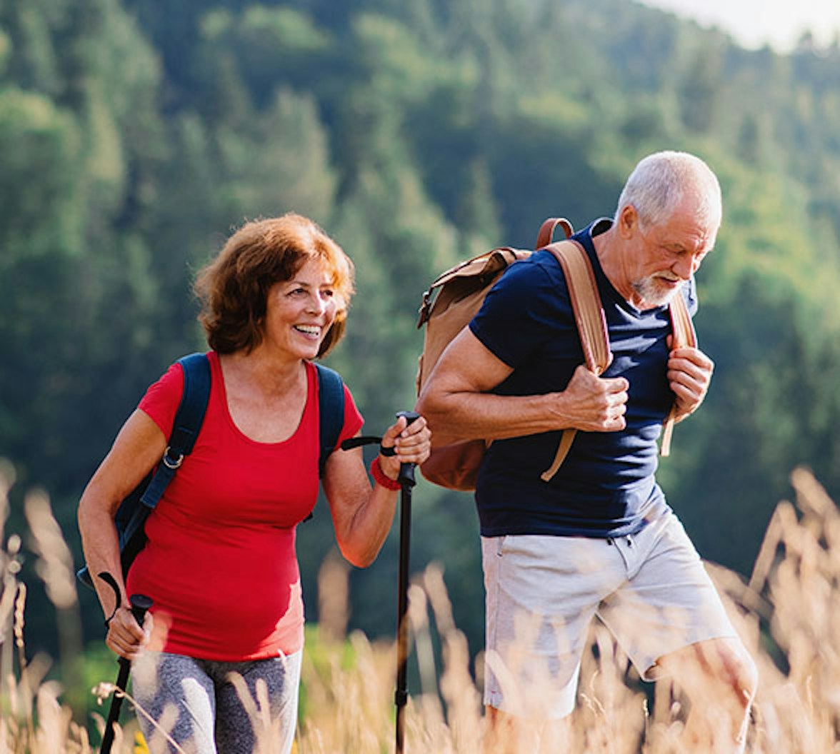 Ein älteres Ehepaar, das gemeinsam in der Natur wandert