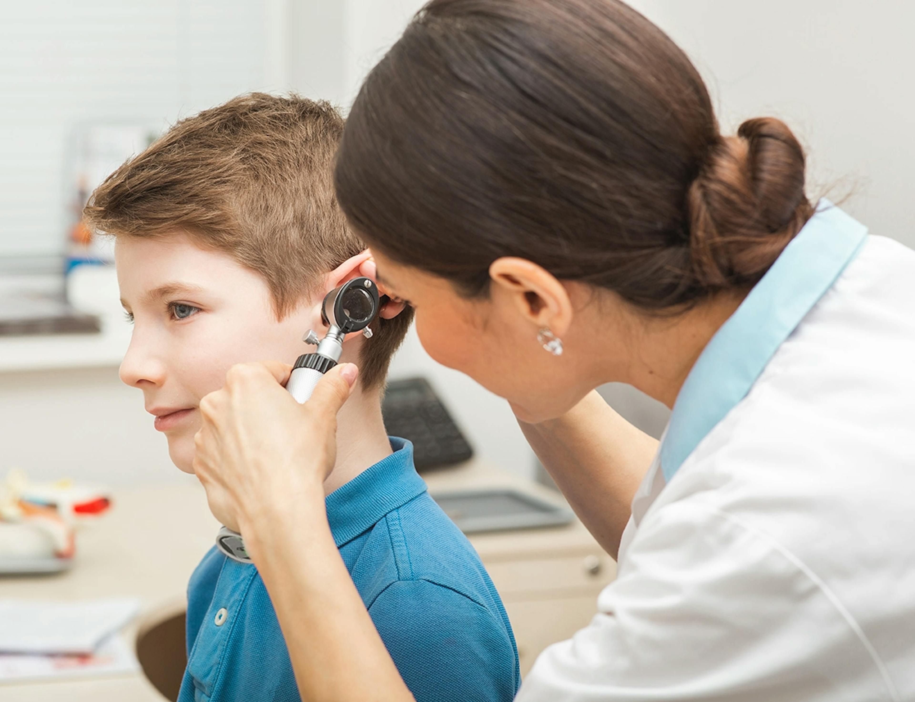 audiologist-examining-boy-ear-using-otoscope
