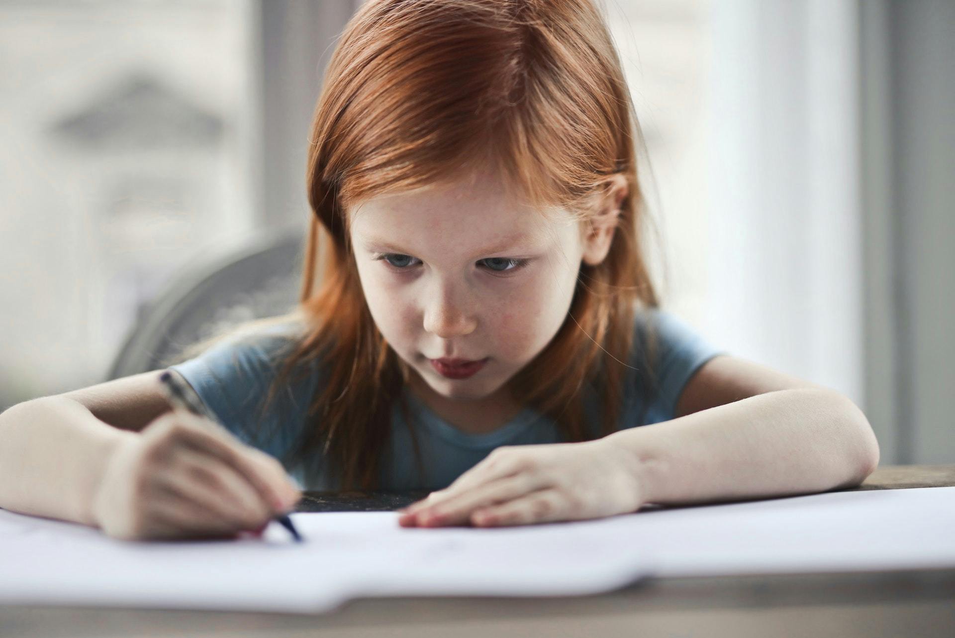 A young girl focuses on a vocabulary strategies worksheet.
