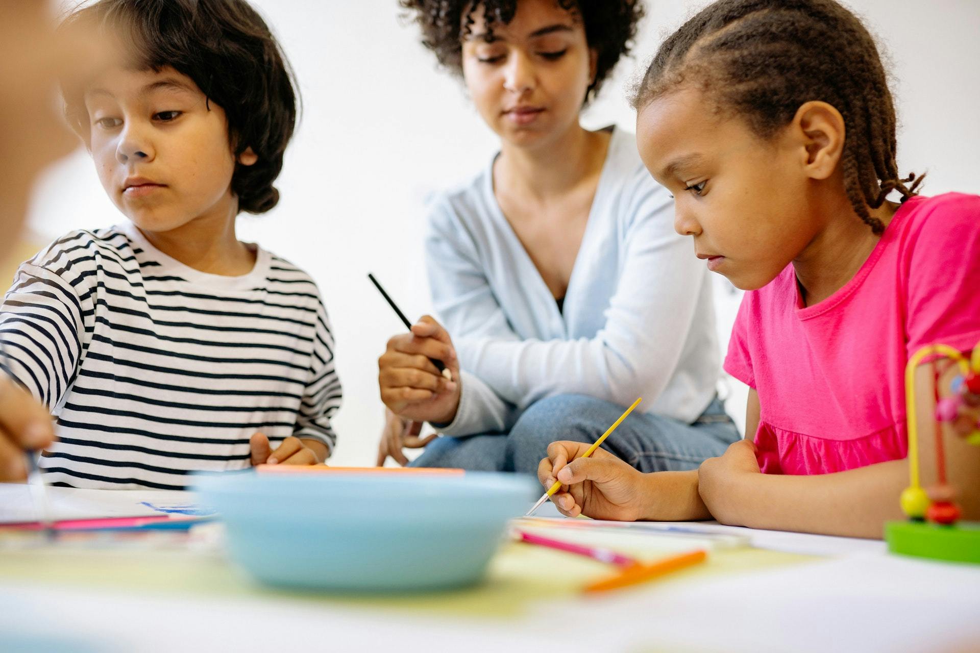 A teacher and two students complete phonemic awareness activities in the classroom. 