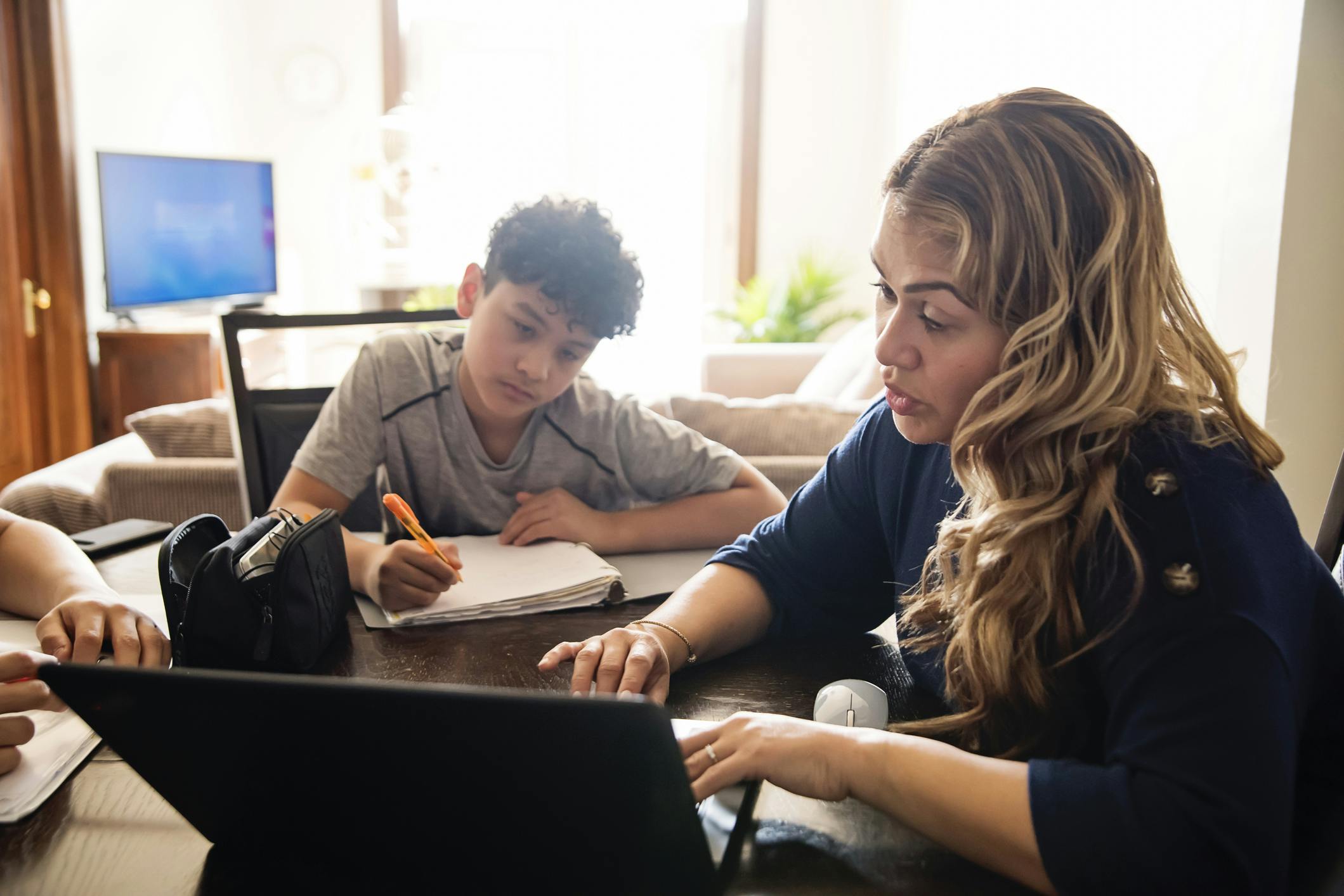 Mother and son working at a laptop together.