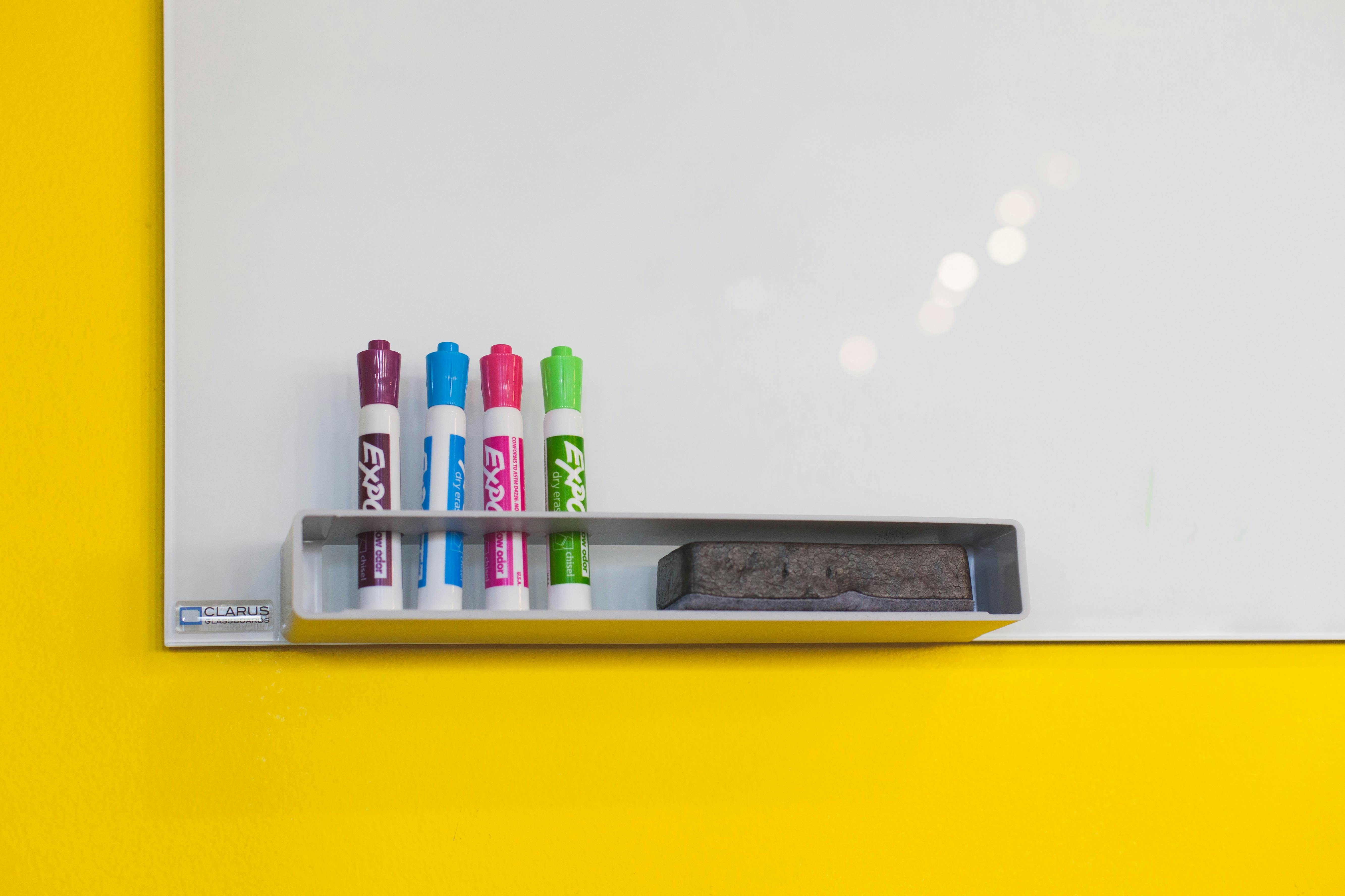 A well-organized white board with dry erase markers and an eraser.