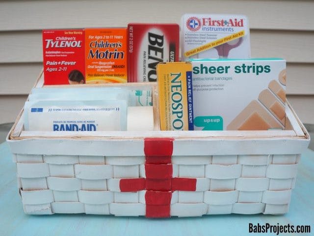 A DIY first aid kit containing band-aids and medicines.